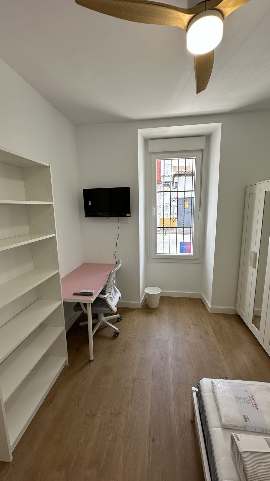 Habitación con estantería, escritorio y silla ergonómica